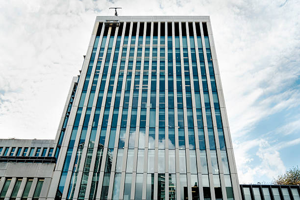 istock Modern office building facade reflecting blue sky and clouds 2244415759