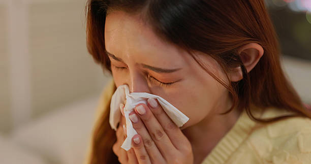 istock Asian female get cold blowing nose home 2244416635