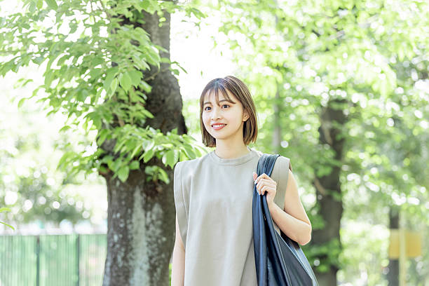 istock Asian woman walking on a green road 2244419600