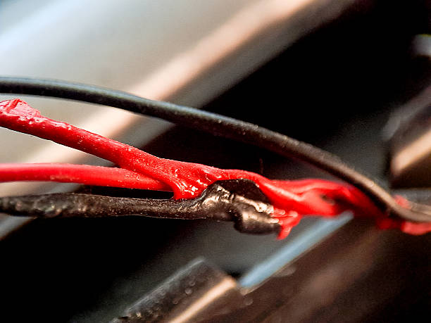 istock Abstract detail featuring electrical wires, showcasing a red wire with black and brown components. 2244420689