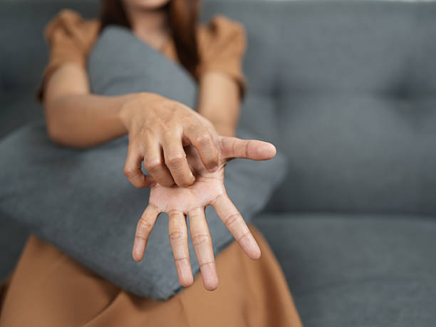 istock Person stretches their hand while sitting on couch, showcasing relaxed posture. soft gray pillow adds comfort to scene, creating cozy atmosphere 2244422556