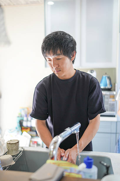 A man is washing his hands at a sink
