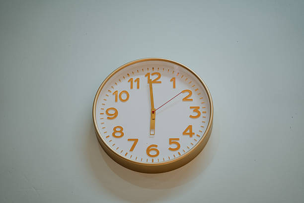 istock On a pristine white wall, a classic clock prominently displays the time as 500, clearly indicating a peaceful early evening or late afternoon moment perfect for relaxation 2244425645