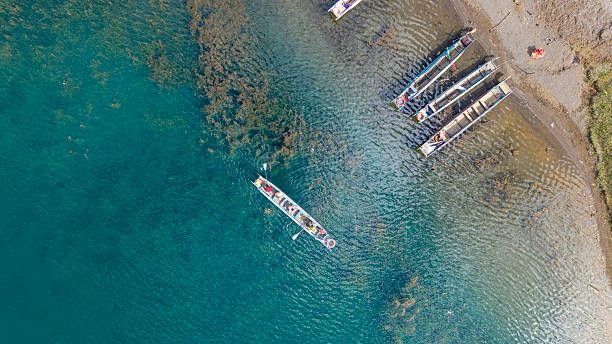 istock Colorful canoes docked at the lakeside pier 2244430895
