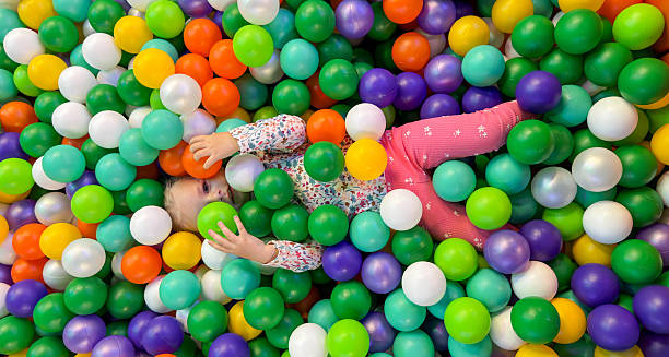 istock Happy Girl Playing and Lying in a Colorful Ball Pit Pool 2244432064