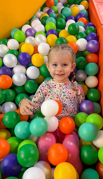 istock Happy Girl Playing and Lying in a Colorful Ball Pit Pool 2244432065