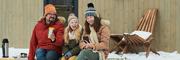 istock Man with Two Women Relaxing Outdoors during Winter 2244433000