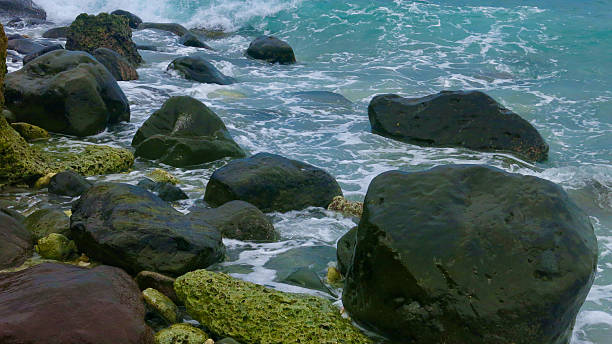 istock Waves crash against dark coastal rocks under turquoise seawater. 2244434061
