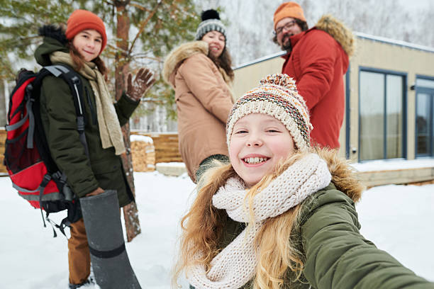 istock Family Enjoying Winter Vacation Outdoors Smiling at Camera 2244434074