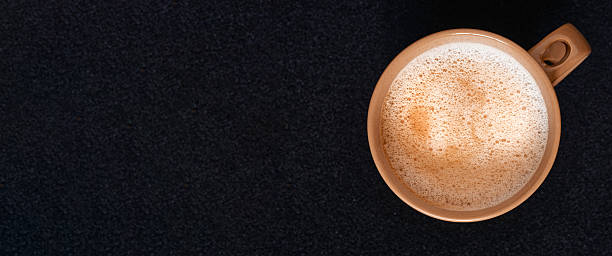 top view coffee cup with cappuccino latte foam on black background