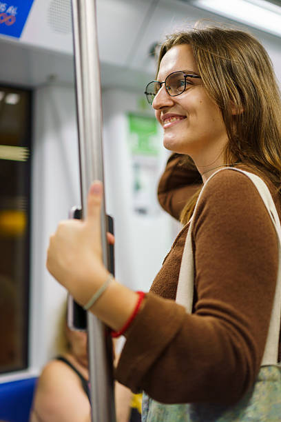 istock Young woman enjoying her metro commute wearing glasses. 2244435113