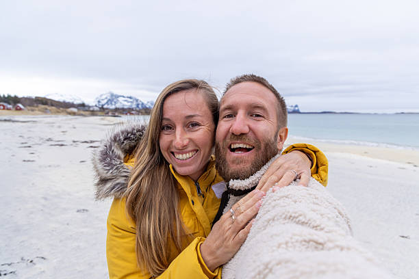 istock Happy Couple Taking Selfie on Winter Beach 2244437702