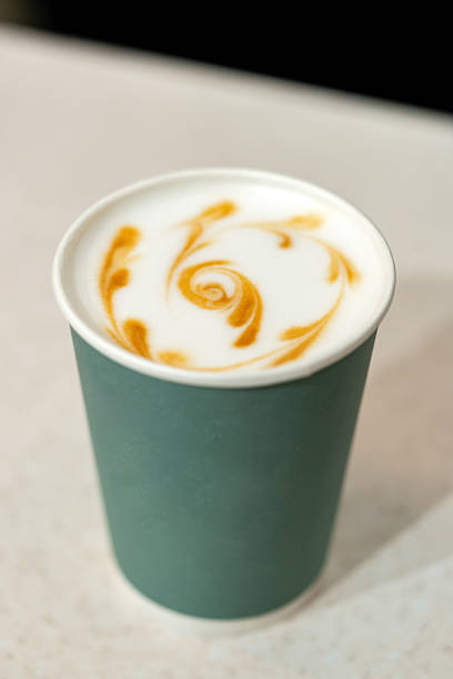 istock Coffee with beautiful latte art in a takeaway cup in a cozy cafe setting 2244438558