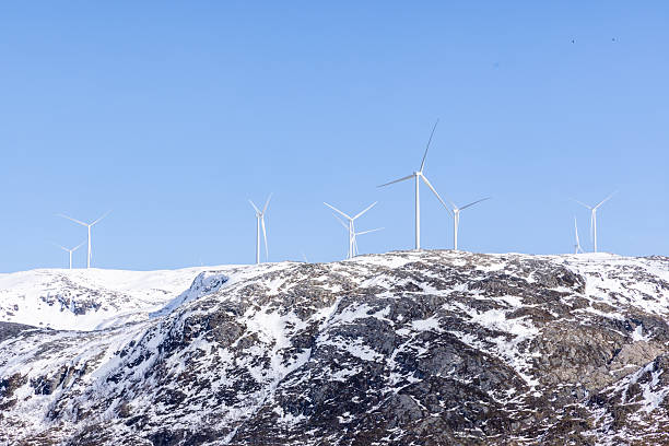 beautiful snow landscape in the Harz mountains with blue sky and trees and wind generator
