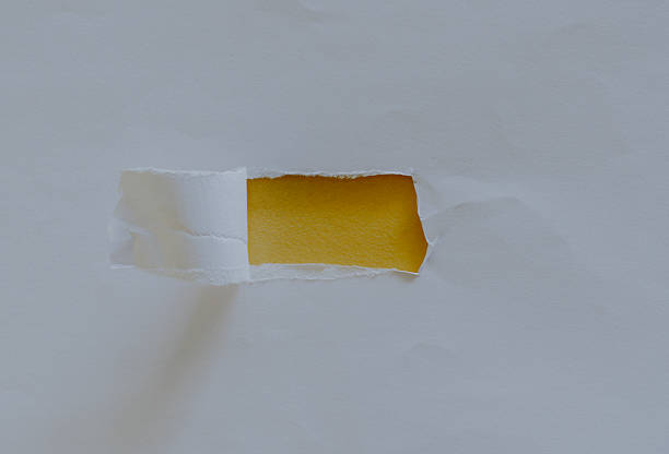 Hole in white torn paper revealing yellow background. Space for text. Mockup.