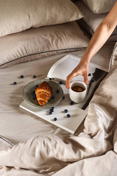 istock Cozy hotel breakfast in bed featuring croissant, coffee, and fresh blueberries 2244444943