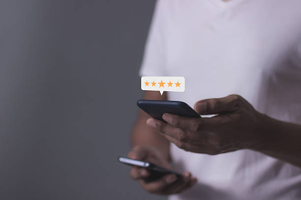 istock Review Customer, Young Man hand using smartphone mobile with five star to review and give 5 stars with very good results in service, Good review 5 star rating choice feedback 2244445959