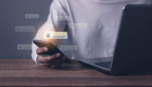 istock Consumer Satisfaction, Young Man hand using Smart Phone and laptop with five star to review and give 5 stars with very good results in service, Good review 5 star rating choice feedback 2244445967