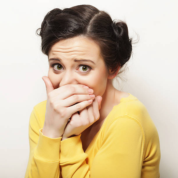 istock woman with hands over mouth. Surprise! 2244448689