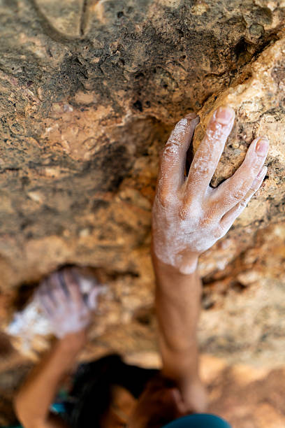 istock fearlessly climbs up the rock using white magnesia powder, holds her hand to the ledge in the relief, 2244456384