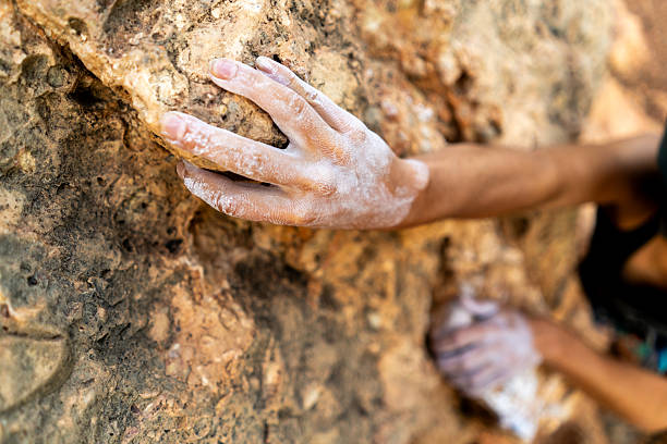 istock fearlessly climbs up the rock using white magnesia powder, holds her hand to the ledge in the relief, 2244456571