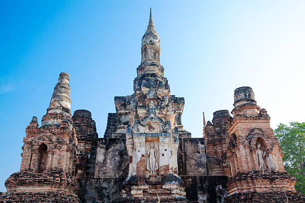 Old and ruined  pagodas with  thai buddha in Sukothai in historical park and travel destination