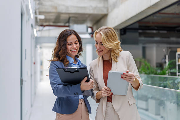 istock Businesswomen discussing project on clipboard and digital tablet 2244458280
