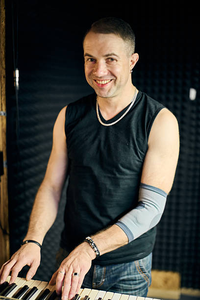 istock Keyboardist rehearses with band in studio 2244459213