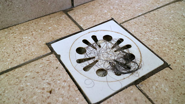 istock Hair clog on bathroom floor drain cover tile 2244462669