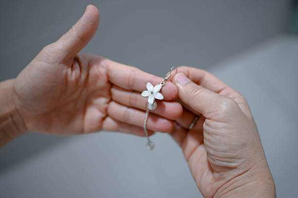 In the soft glow of the mirror, she adorns herself with jewelry that reflects her personal style and inner confidence.