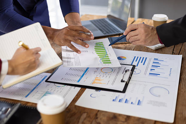 istock Business people analyzing financial documents, discussing charts and graphs showing company growth and using calculator for accounting and budget. 2244463528
