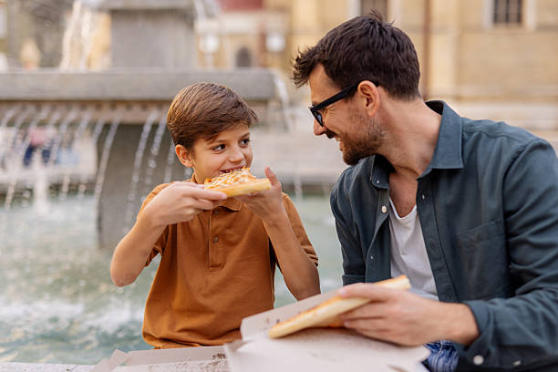 istock Father and Son Sharing Fun Meal Outside 2244463653