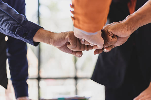 istock Business people joining hands together, demonstrating teamwork. 2244463724