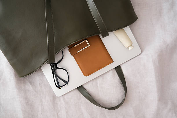istock A stylish and chic green bag that is filled with all the essential items you need for work and daily activities of woman - notebook, glasses, copybook, handcream. 2244464433