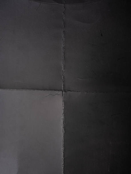 istock High-resolution texture of gray paper or cardboard featuring a clear cross-fold pattern with natural creases and light scratches. 2244465545