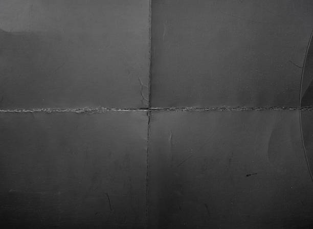 istock High-resolution texture of gray paper or cardboard featuring a clear cross-fold pattern with natural creases and light scratches. 2244465548