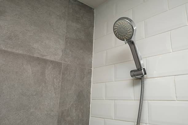 istock Wall-mounted handheld shower head in modern bathroom 2244466222