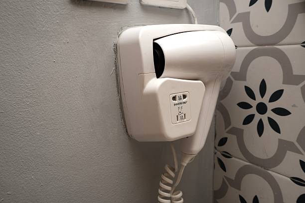 Wall-mounted hair dryer in modern tiled bathroom