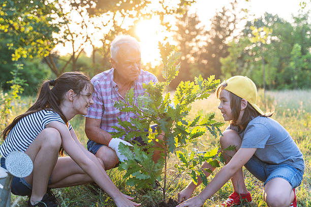 istock Grandfather Teaching Kids About Tree Planting 2244466614