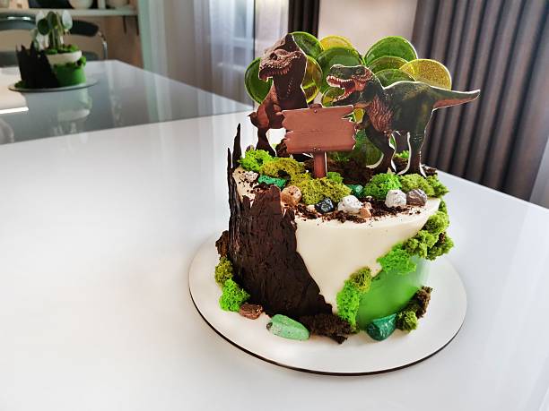 istock Birthday cake with two dinosaur figurines on the surface 2244467809