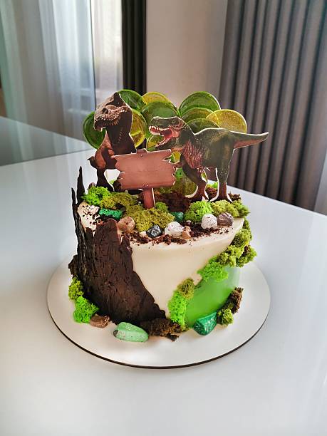 istock Sweet birthday cake with two stylized dinosaurs on the surface 2244467831