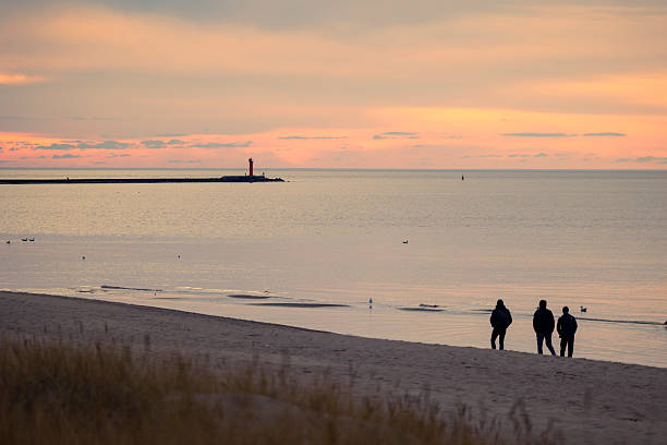 istock A beautiful summer sunset scenery with people silhouettes walking on a beach, enjoying Baltic Sea costline. 2244470232