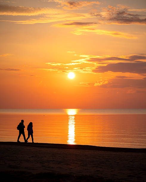 istock A beautiful summer sunset scenery with people silhouettes walking on a beach, enjoying Baltic Sea costline. 2244470281