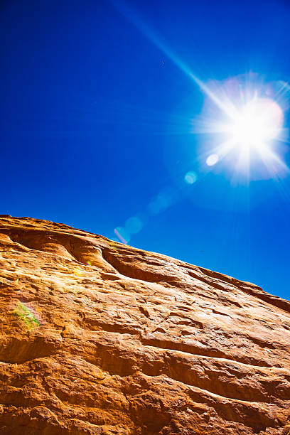 This photograph captures an upward view of sun-scorched sandstone meeting the blinding desert sun — a union of rock and radiance.The intense cobalt sky becomes a spiritual void, the light bursting across it in an almost divine flare, while the surface of the rock below glows with molten luminosity.This composition transforms geology into devotion — the moment where the material world dissolves into light.It is the culmination of the pilgrimage that began in The Pillars of Silence: here, the seeker finds not structure, but revelation.No form remains untouched; everything is consumed in brilliance.