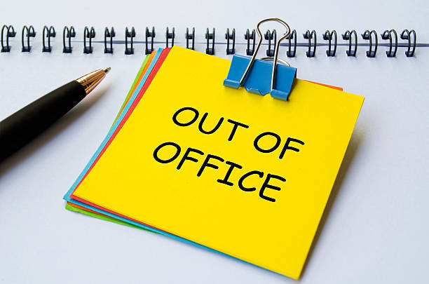 istock Out of office text on yellow notepad with white notebook background. Getaway or on a vacation concept. 2244471686