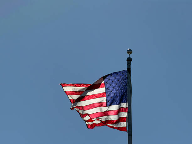 istock American flag waving proudly on flagpole 2244479675