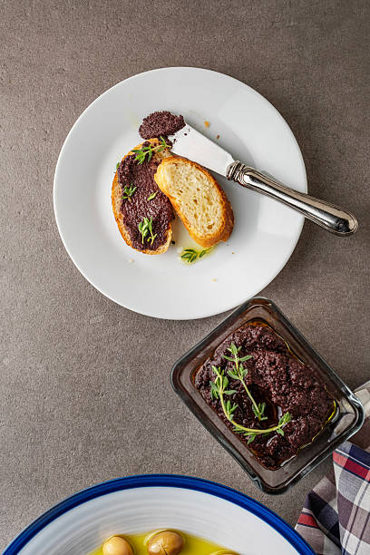 Olive paste. Olive puree. Bread with olive pate. Black olive Tapenade. Healthy breakfast pate products.