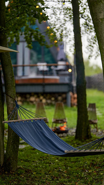 istock Relaxing outdoor scene with a hammock, trees, and a cozy fire pit 2244487522