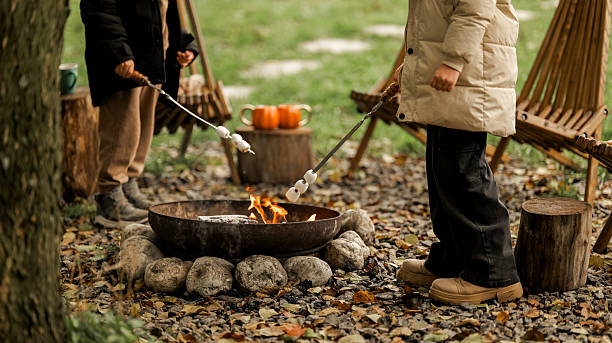 istock People roasting marshmallows over a campfire on a crisp autumn day 2244487531