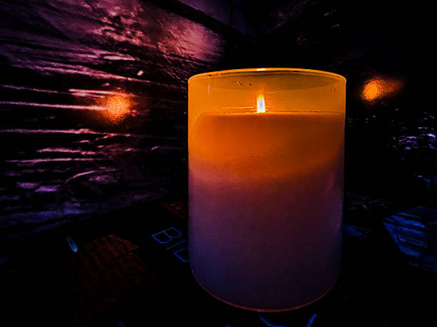 istock Dramatic Single-Wick Candle with Orange and Purple Color Gradient Illuminating a Dark, Abstract Background for Hypnotic Mood and Intense Ambiance. 2244487703